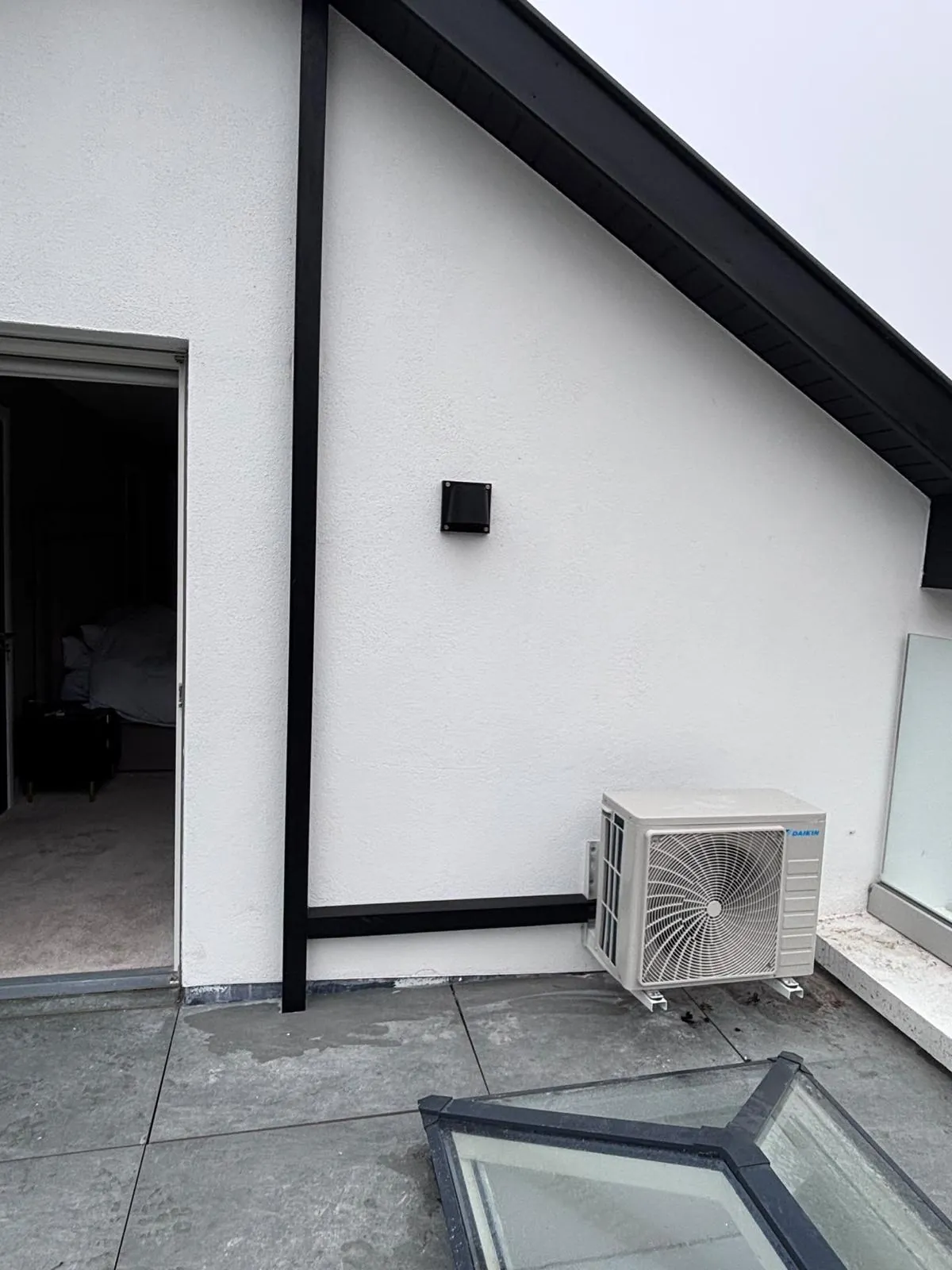 Daikin air conditioning outdoor unit sited on a flat roof terrace beside a bedroom at a Cork property